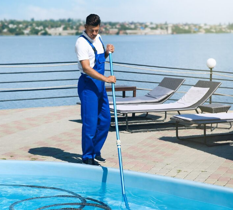Professional one time pool service cleaning a backyard pool, including skimming, vacuuming, and chemical balancing.